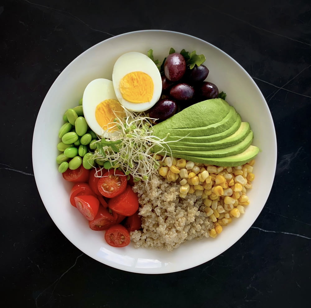 un bol blanc rempli de légumes et d’œufs