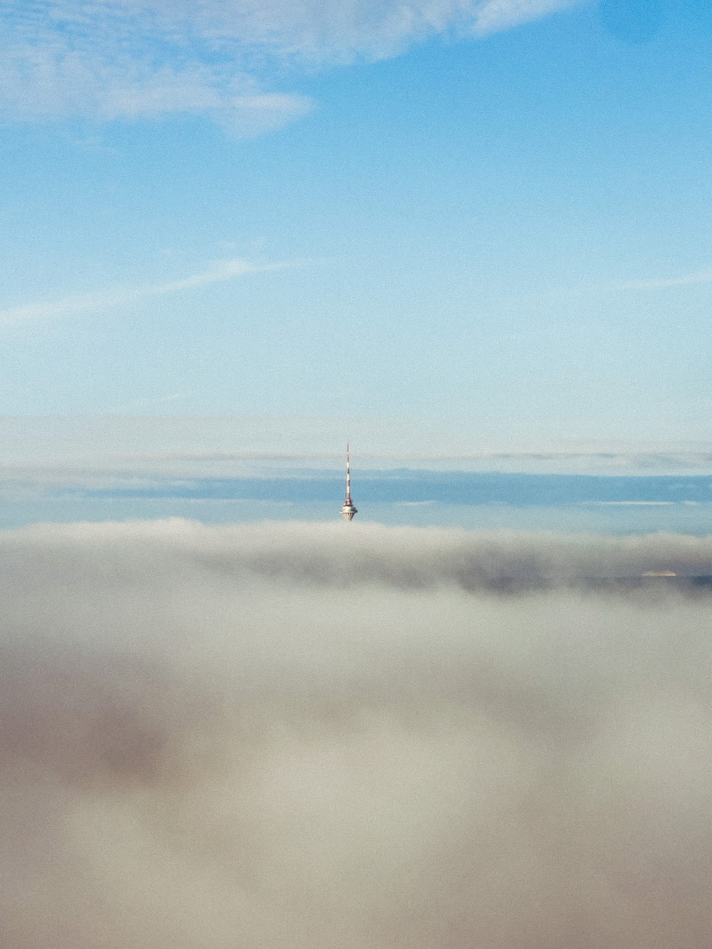 a very tall tower towering over a cloud filled sky