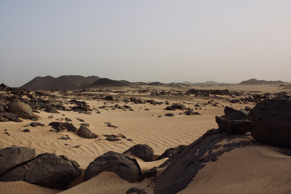 Eine Wüste mit Felsen und Sand im Vordergrund