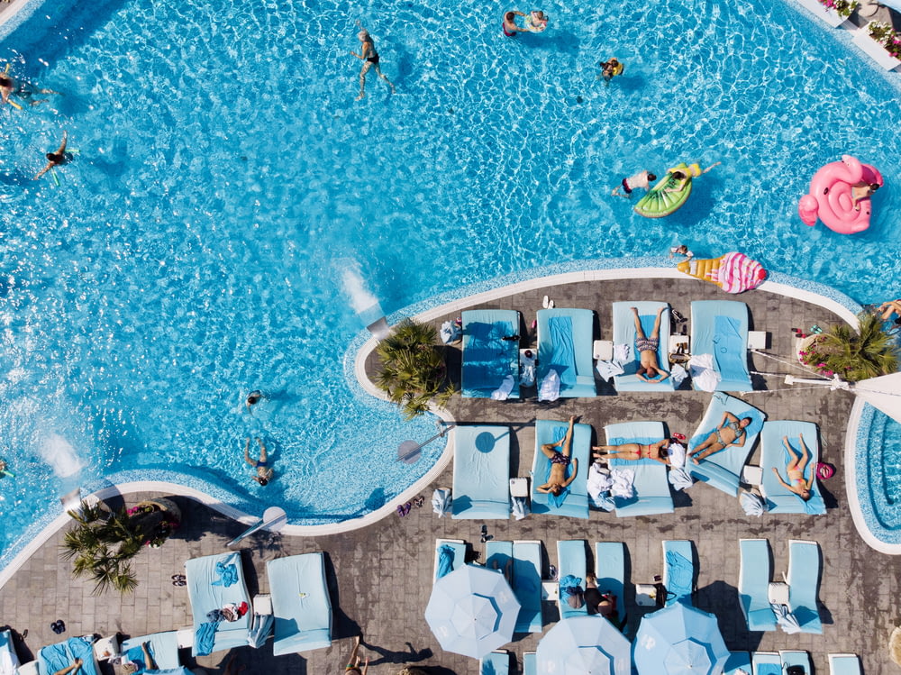 an overhead view of a pool with lounge chairs and inflatable toys