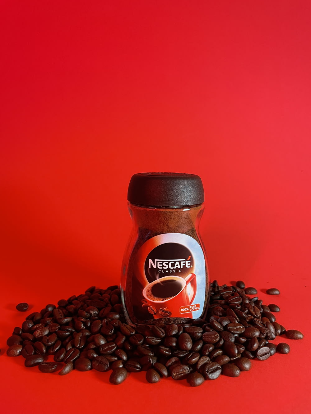 a jar of coffee beans sitting on top of a pile of coffee beans