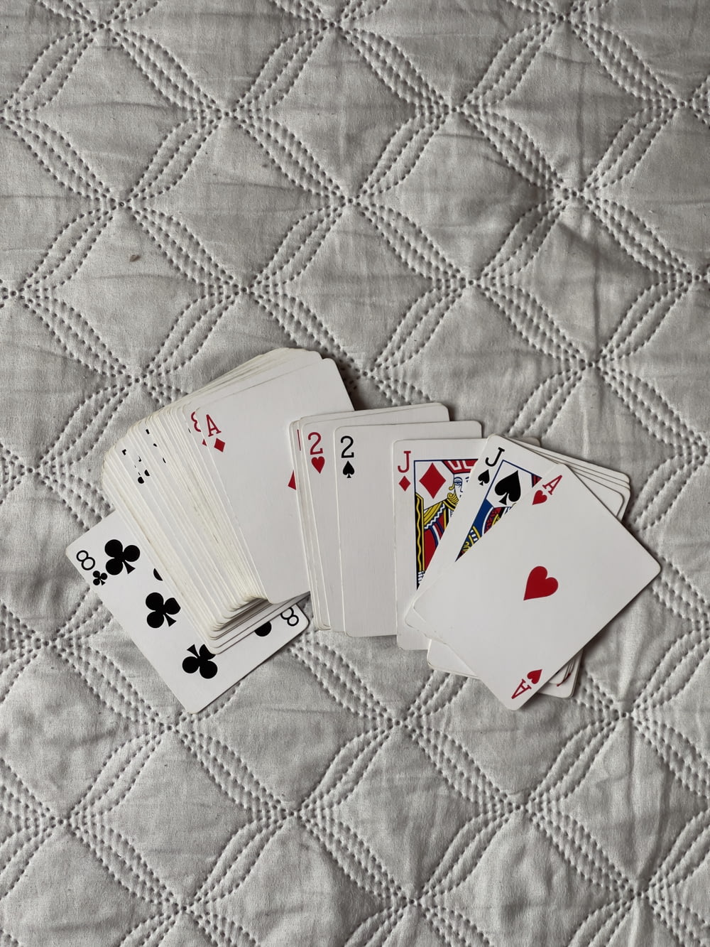 Quattro carte da gioco sono posate su una trapunta