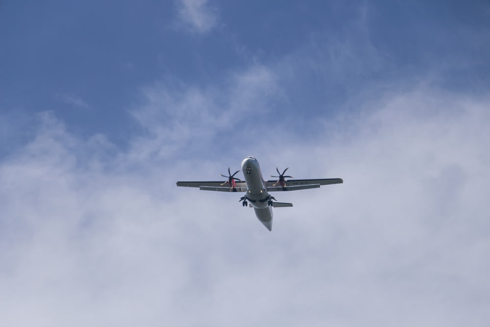 an airplane is flying in the sky on a cloudy day