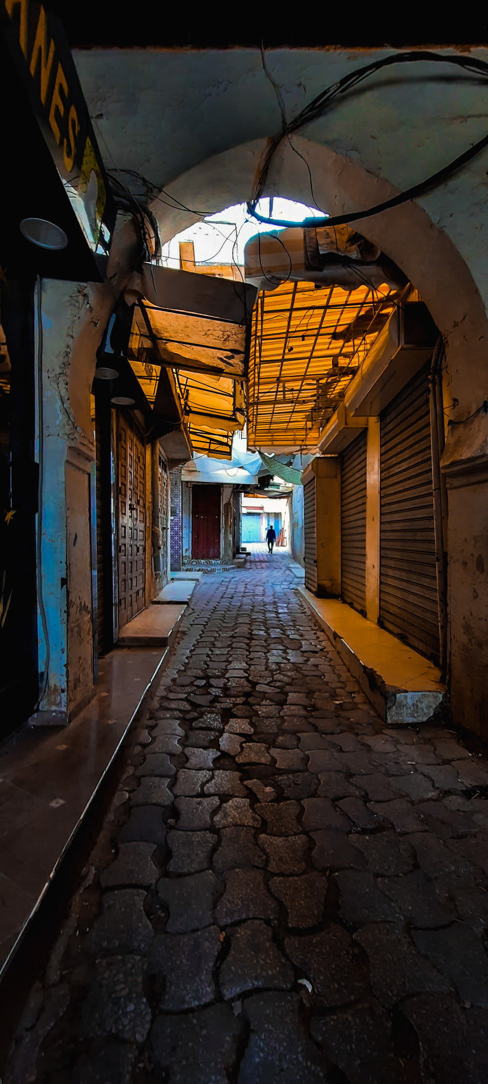 an alley way with a person walking down it