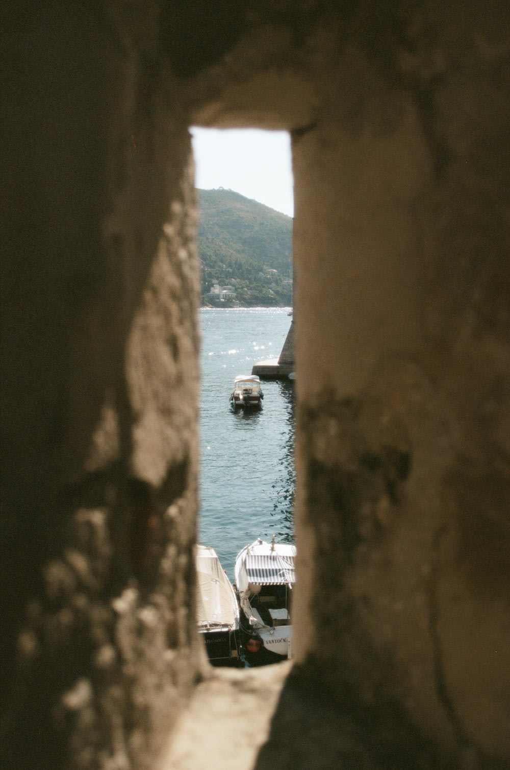 a view of a body of water through a hole in a wall