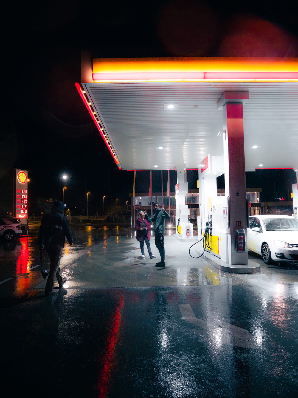 a group of people standing at a gas station