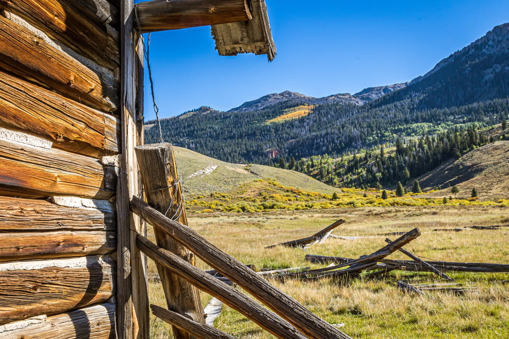 a wooden cabin in the mountains with mountains in the background