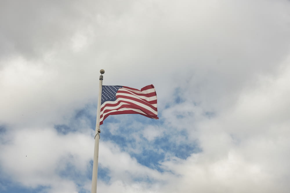 an american flag flying in the wind on a cloudy day