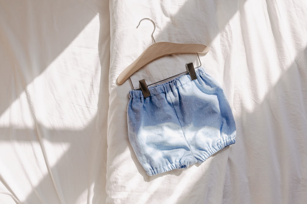 a pair of blue shorts hanging on a hanger