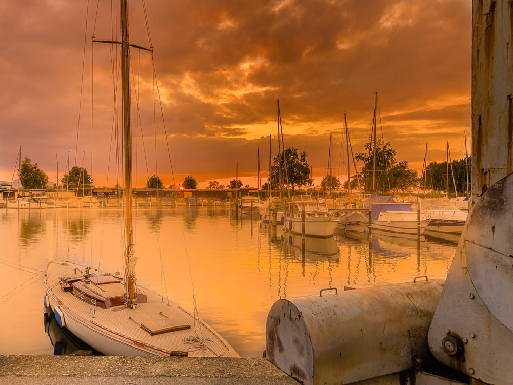 a sailboat sits in the water at sunset
