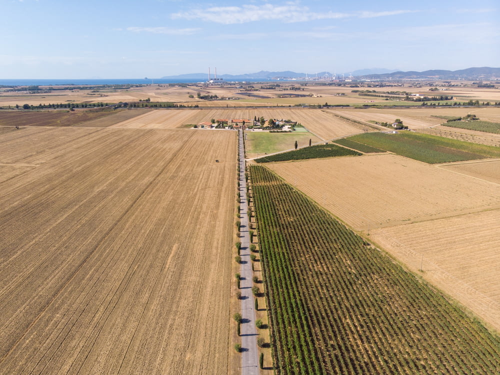 an aerial view of a farm field with a train on the tracks