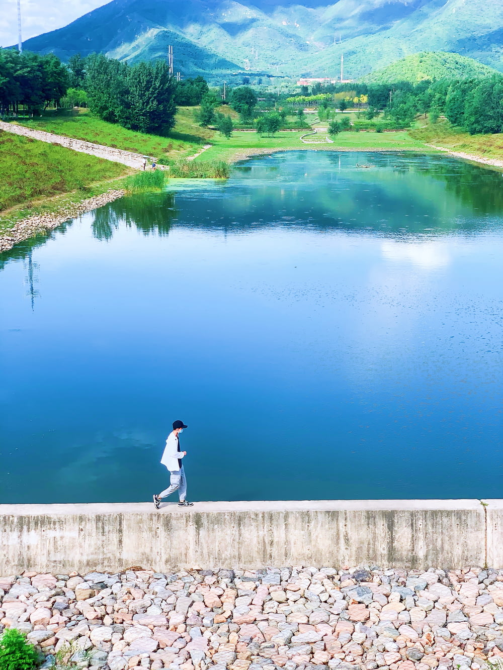 a person walking along a wall near a body of water