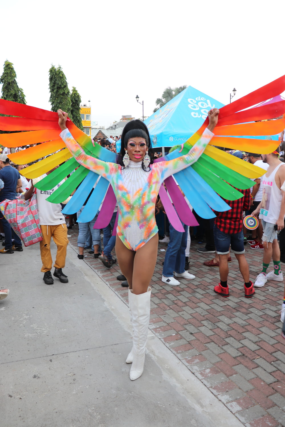 a woman in a colorful costume is holding a kite