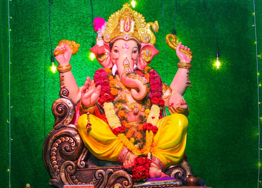 a statue of a ganesh sitting on a chair
