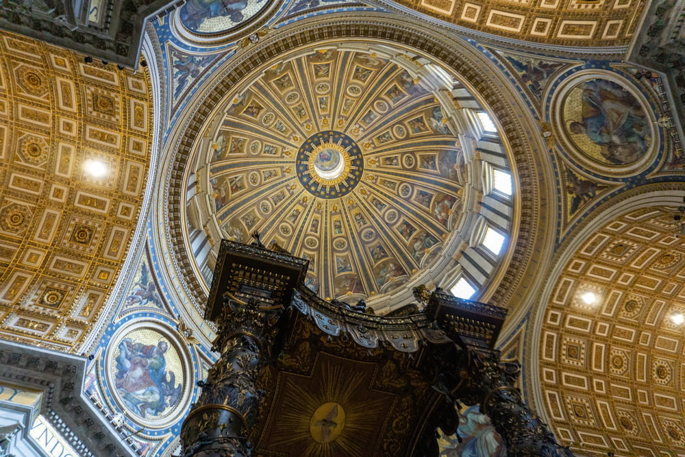 the ceiling of a church with a dome and paintings on it