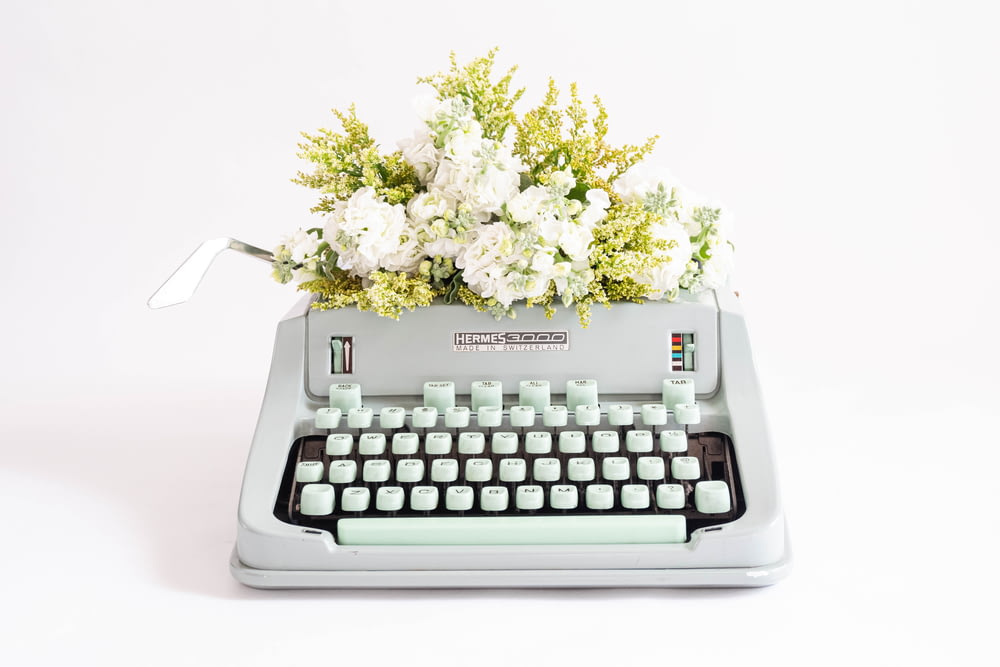 eine Schreibmaschine mit einem Blumenstrauß darauf