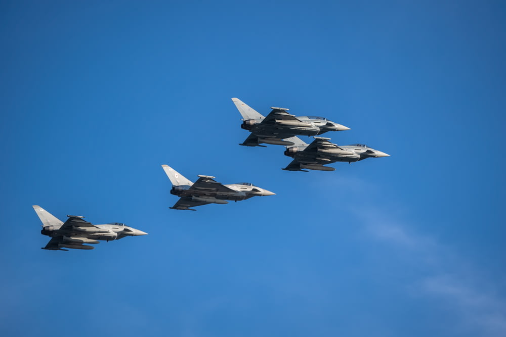 um grupo de caças voando através de um céu azul