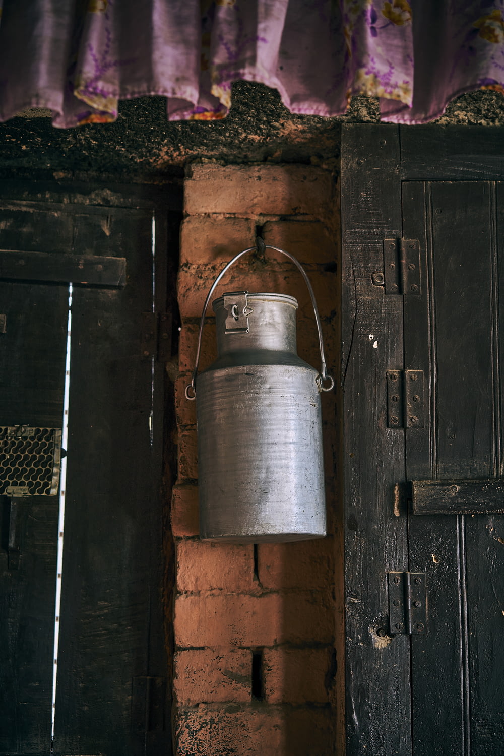 a metal bucket hanging from a brick wall
