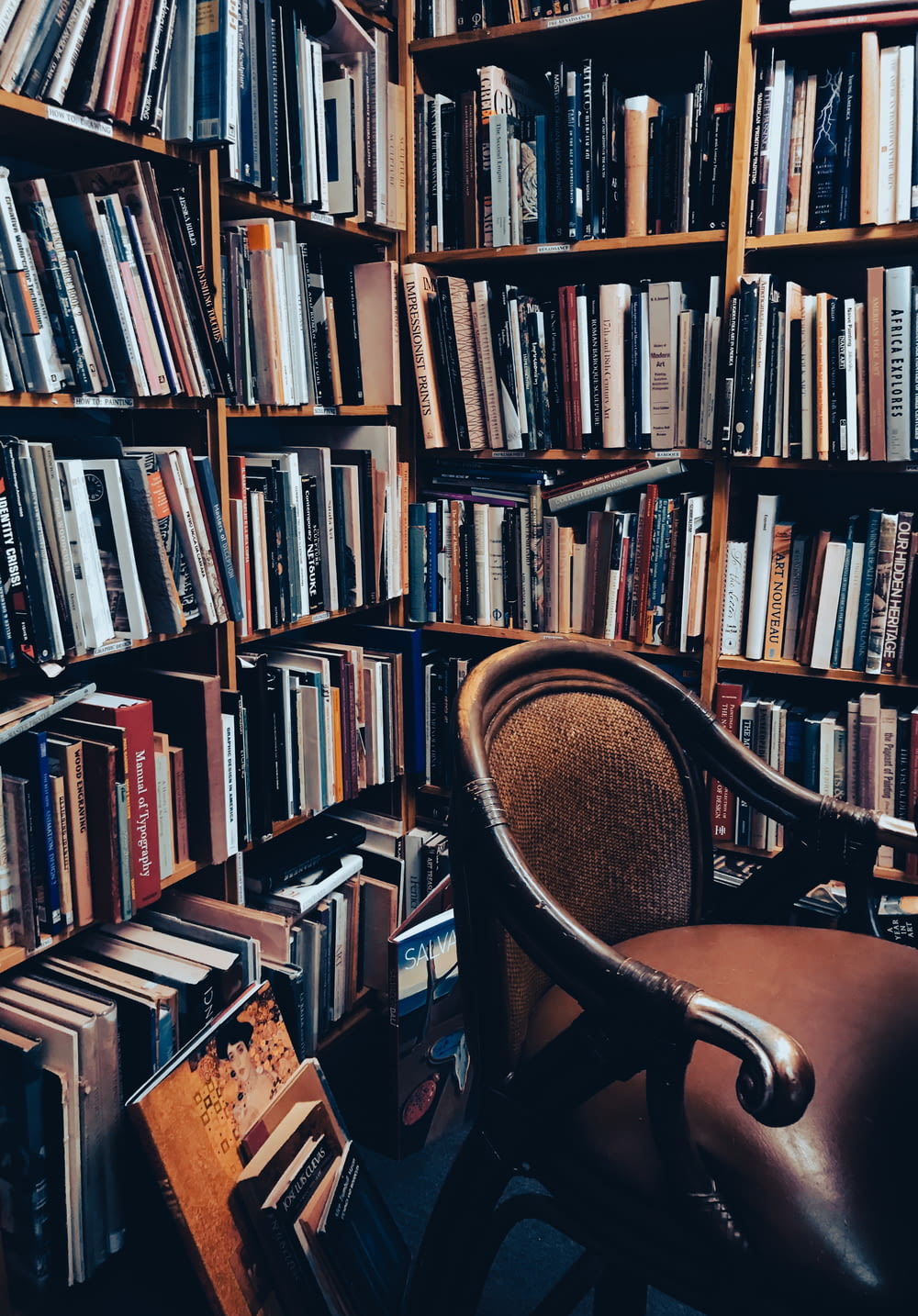 une chaise devant une étagère pleine de livres