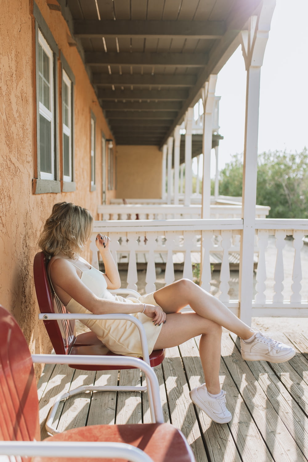 a woman sitting in a chair on a porch