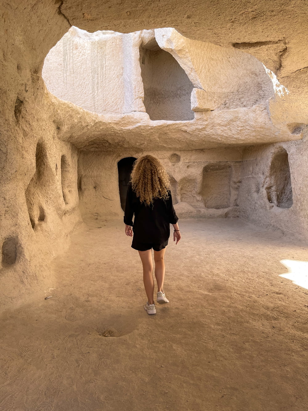 Una mujer está caminando por un área similar a una cueva