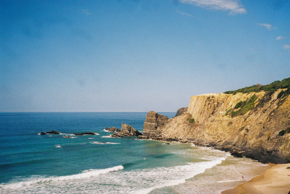a view of a beach with a cliff in the background