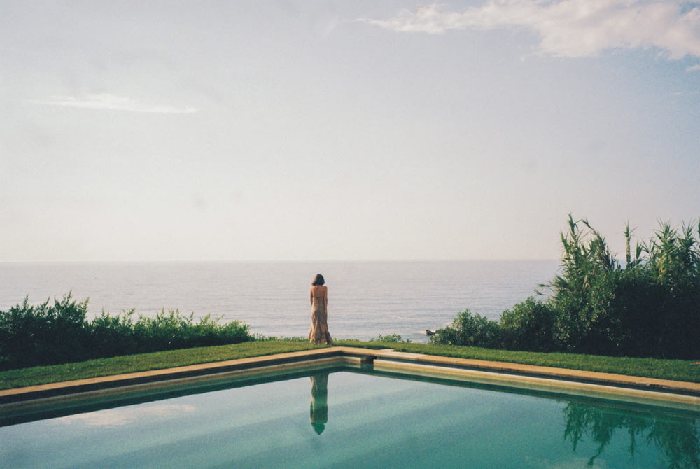 a person standing on the edge of a swimming pool