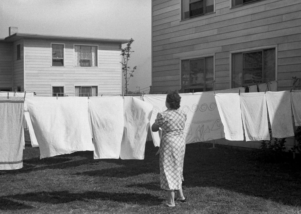 a woman standing in front of a line of clothes
