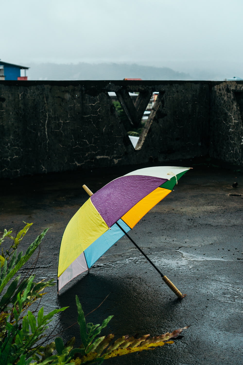 a colorful umbrella sitting on top of a wet ground