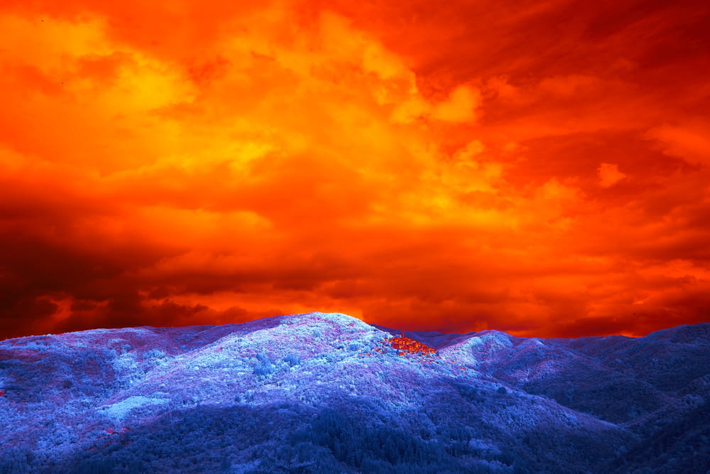a red and blue sky over a mountain range