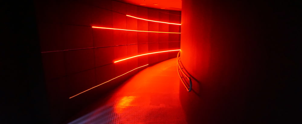 un lungo corridoio con una luce rossa proveniente da esso