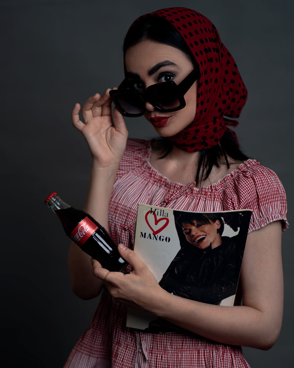 Una mujer con un vestido rojo sosteniendo una botella de vino