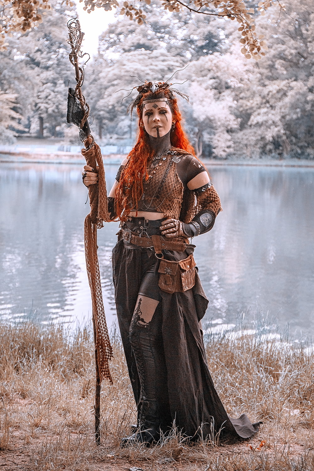 a woman with red hair is holding a stick