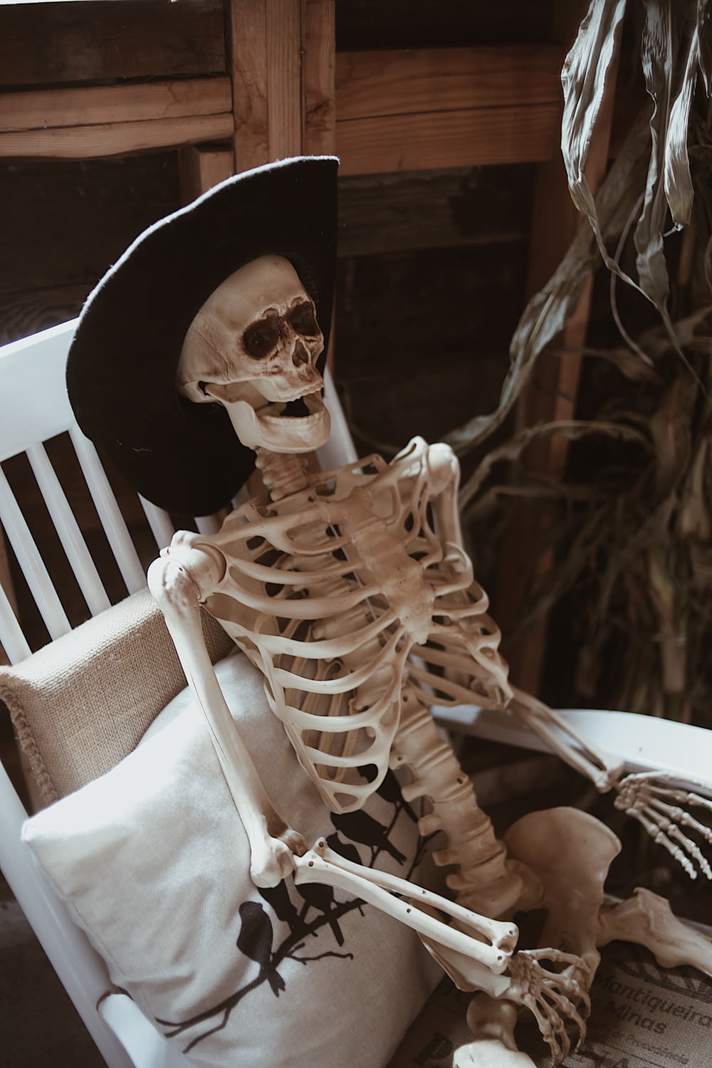 um esqueleto sentado em uma cadeira com um chapéu