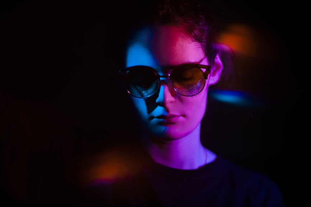 a woman wearing sunglasses in a dark room