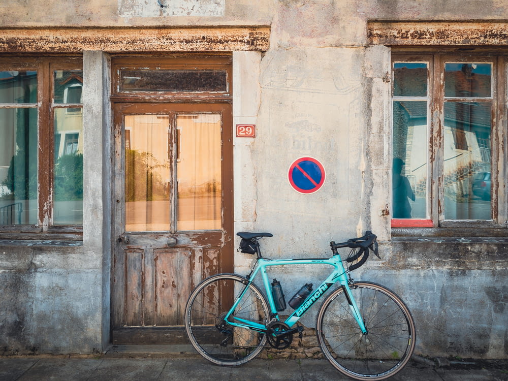 a blue bicycle parked in front of a building