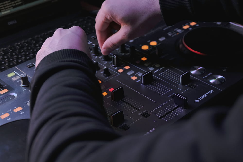 a person using a dj controller in front of a laptop