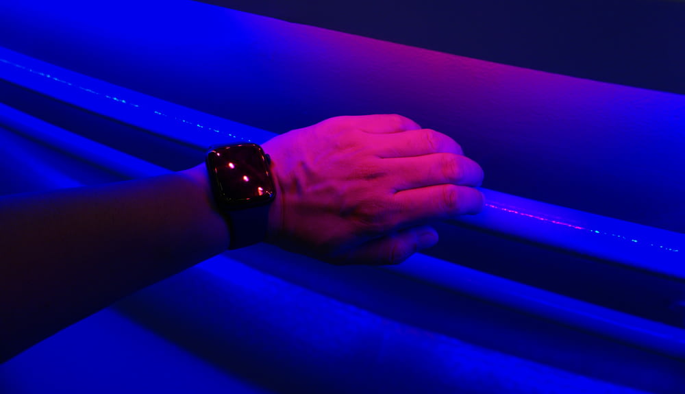 a person's hand holding onto a blue light