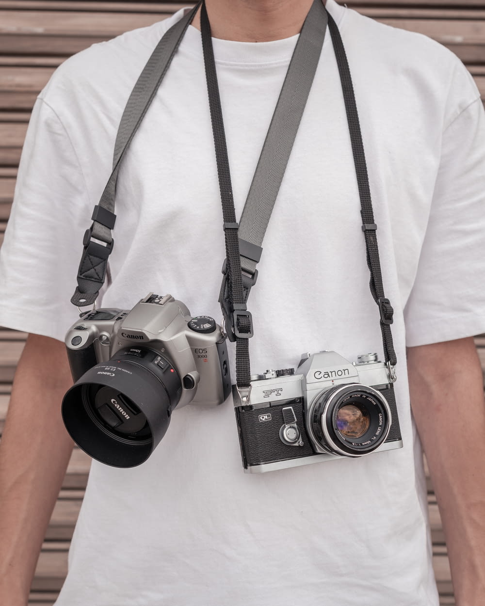 a man wearing a camera strap and holding a camera