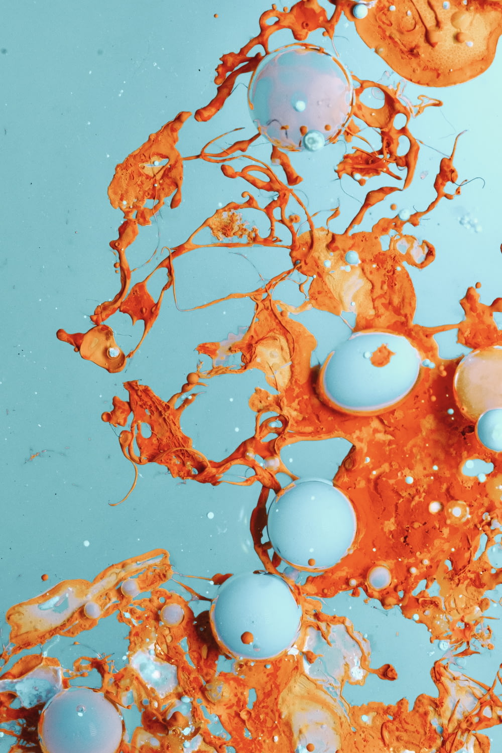 a blue and orange liquid with orange and white bubbles