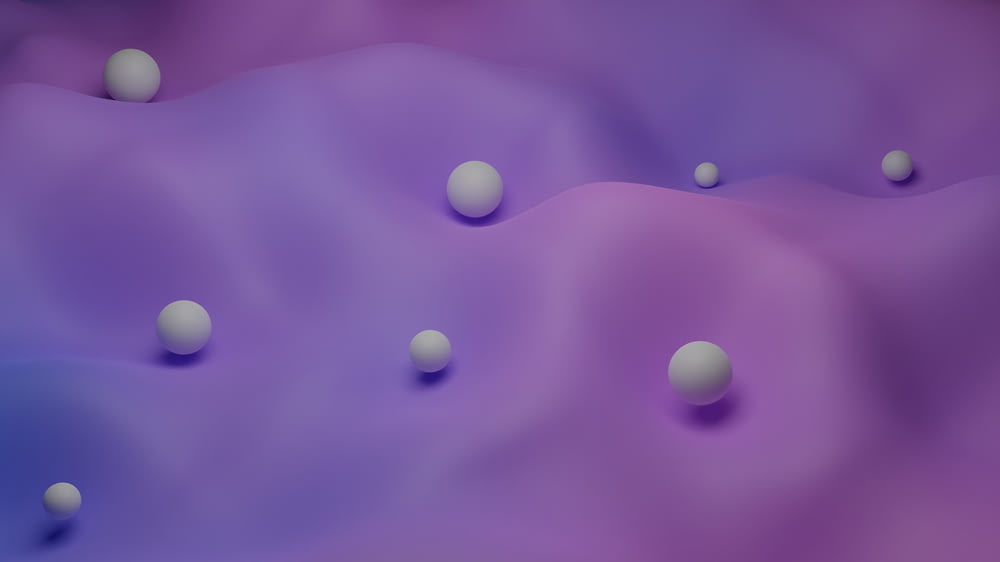 a group of white balls floating on top of a purple background