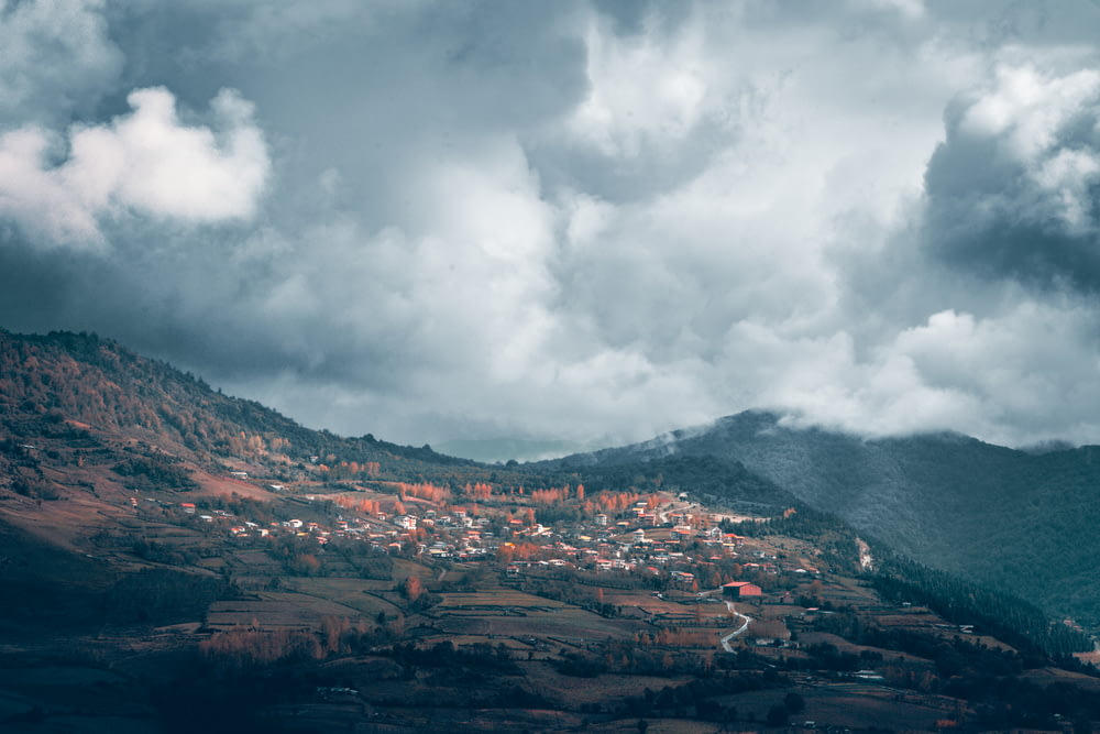Vue d’un village sur une colline sous un ciel nuageux