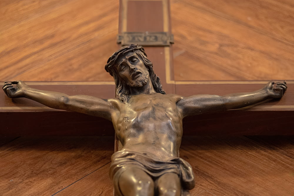 木製の十字架に乗ったイエスの銅像