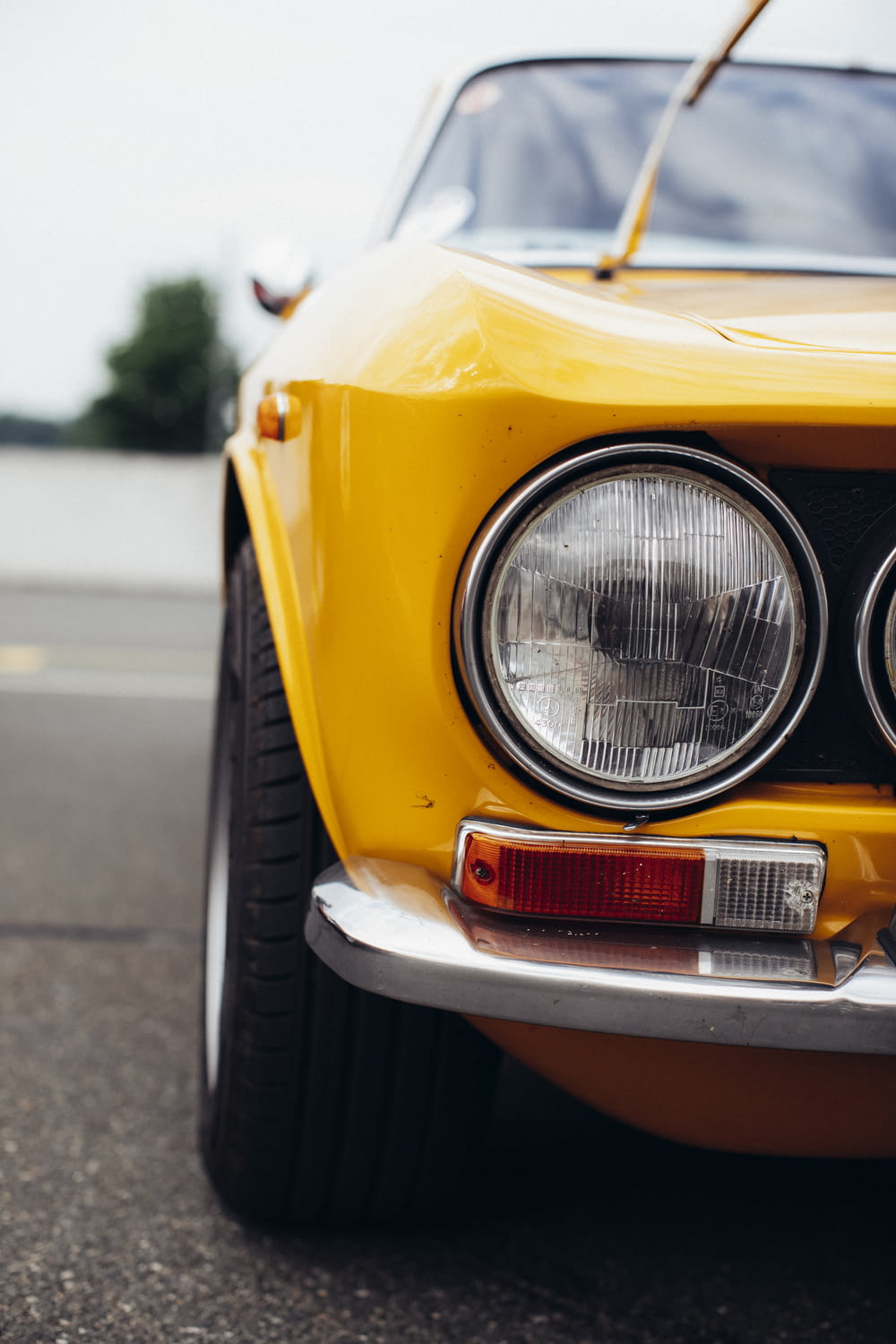 a close up of the front of a yellow sports car