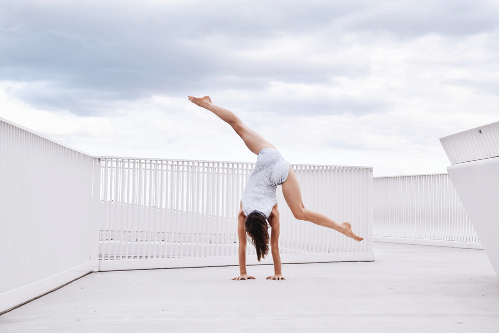 a woman is doing a handstand on the ground