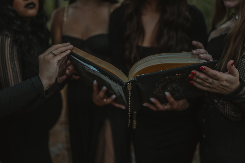 a group of women standing next to each other holding a book