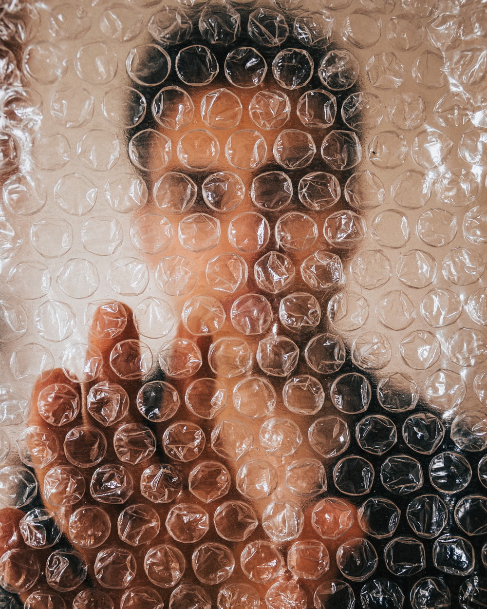 a close up of a person's face behind a bubble wrap