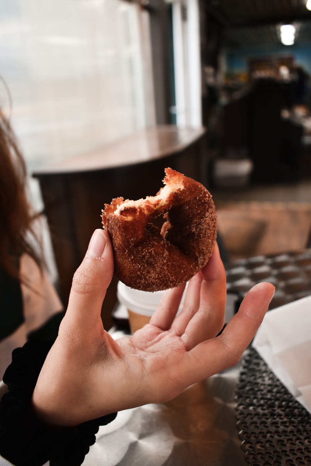 a person holding a half eaten doughnut in their hand