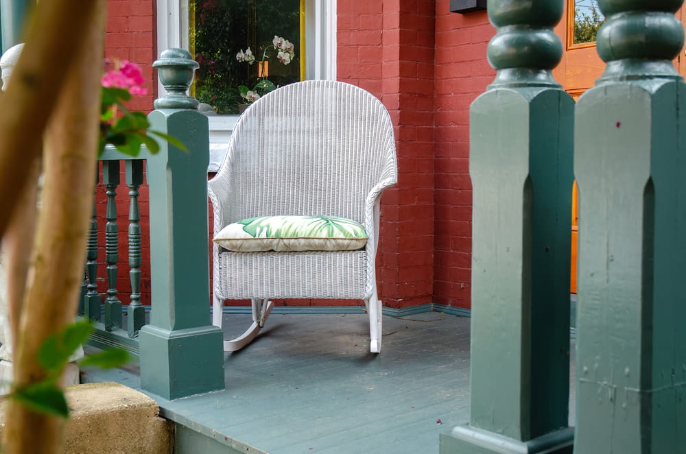 a white rocking chair sitting on a porch