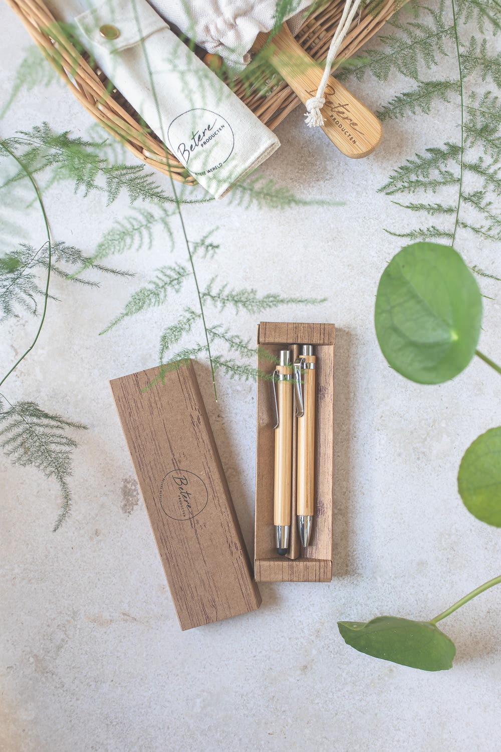 a couple of pens sitting in a wooden box next to a plant